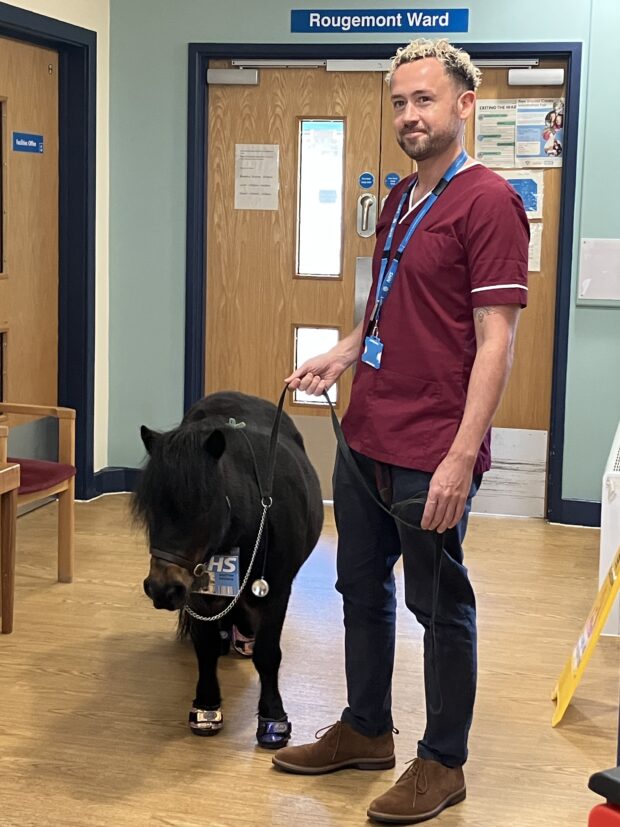 Staff member at Franklyn Hospital in Exeter with Patrick the pony