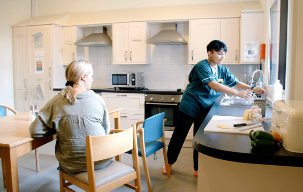 Care worker with elderly lady in kitchen