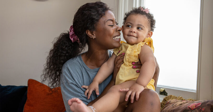 Mother and baby sitting together and smiling