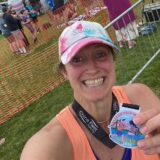Jo at showing off her medal after she has finished the half marathon.