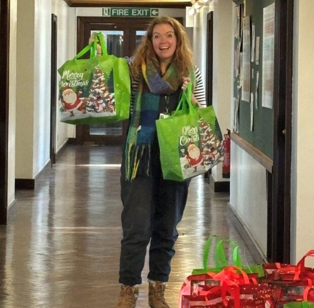 Christmas Hamper Team member holding a Christmas Hamper bag.