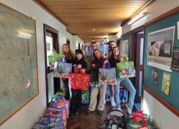 Picture of the Christmas Hampers Team holding the hamper bags.