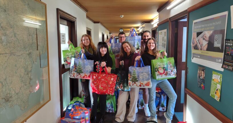 Picture of the Christmas Hampers Team holding the hamper bags.