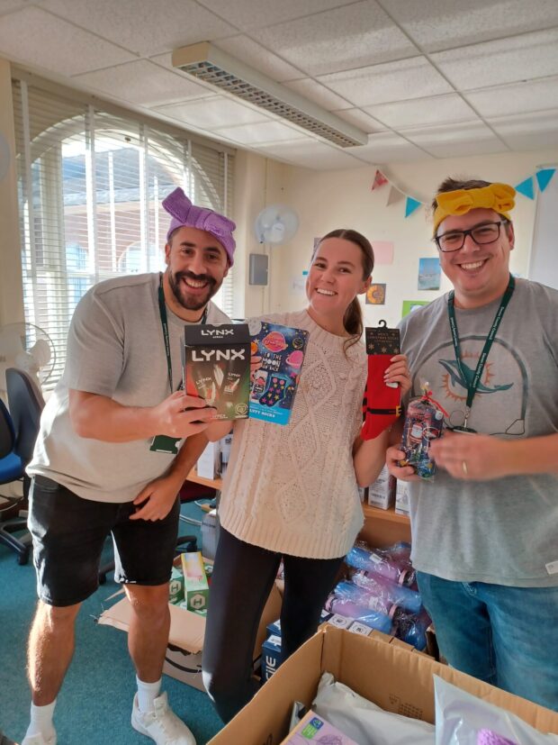 3 of the Christmas Hamper Team helping to pack hamper bags.