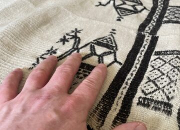 An antique blanket being handled by a patient at an objecting handling session for patients at Franklyn Hospital in Exeter.