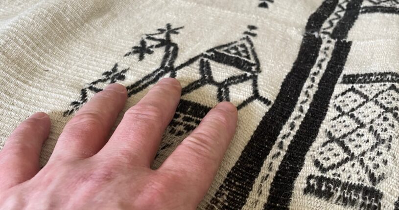 An antique blanket being handled by a patient at an objecting handling session for patients at Franklyn Hospital in Exeter.