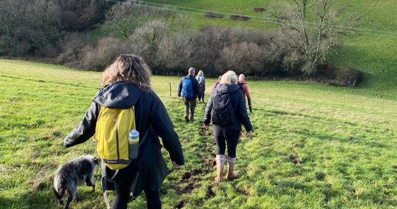 People doing the challenge and walking through a field.