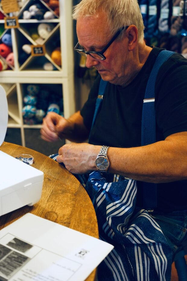Someone taking part in the men's sewing group doing some stitching.