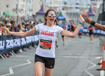 A runner at the Brighton Marathon high fiving a spectator.
