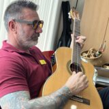 Staff member playing the guitar at the event.
