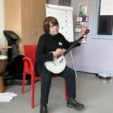 Staff member playing the banjo at the event.