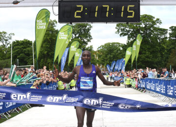 A runner crossing the finish line at the Edinburgh Marathon.
