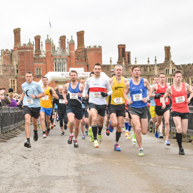 Runners at the Hampton Court Half Marathon running in front of Hampton Court.