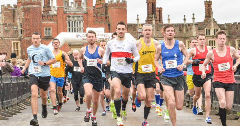 Runners at the Hampton Court Half Marathon running in front of Hampton Court.