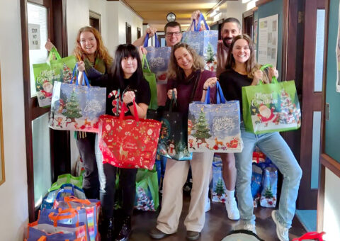 Picture of the Christmas Hampers Team holding the hamper bags.