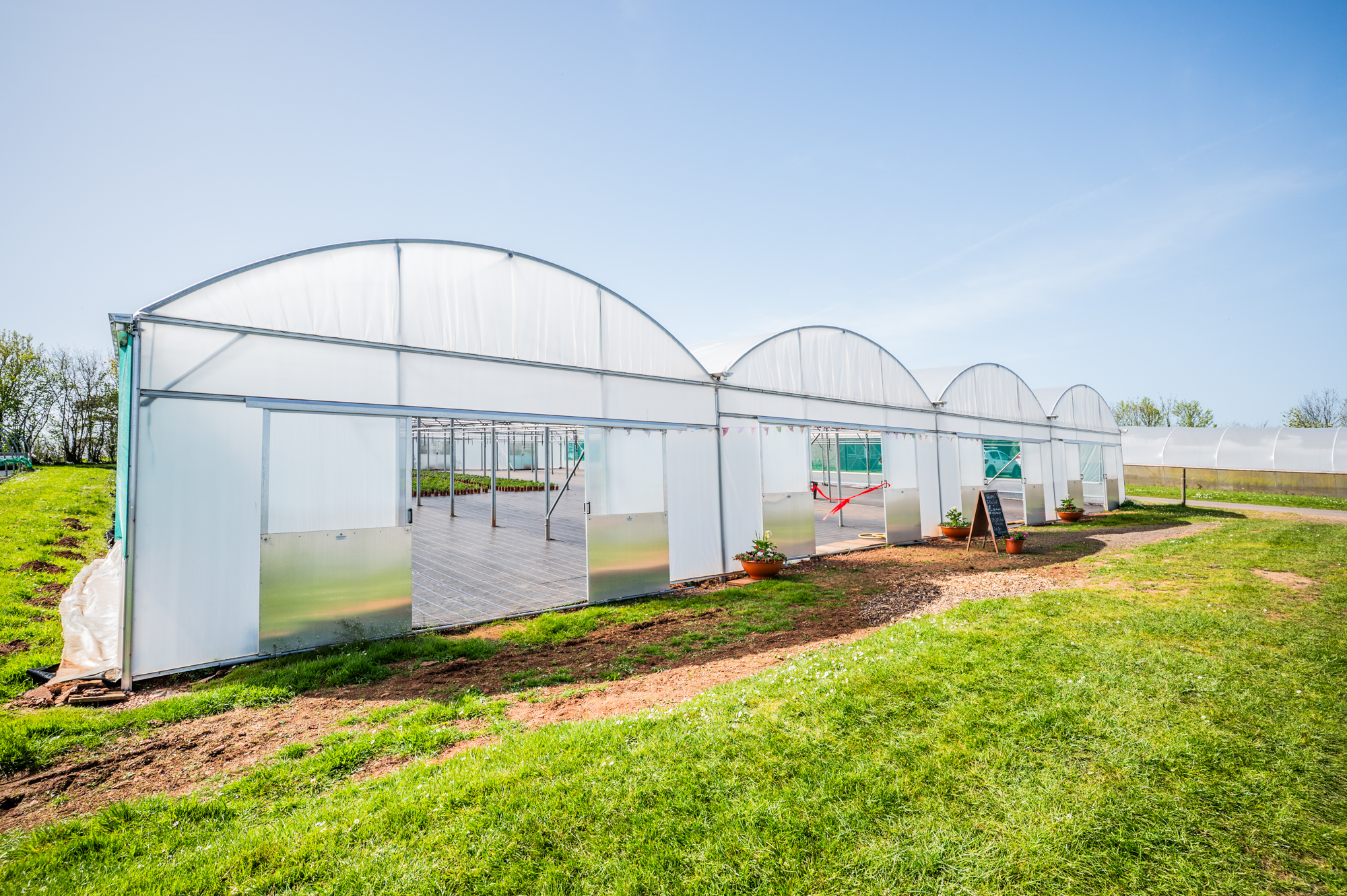 Picture of the outside of the new polytunnel on a lovely sunny day.